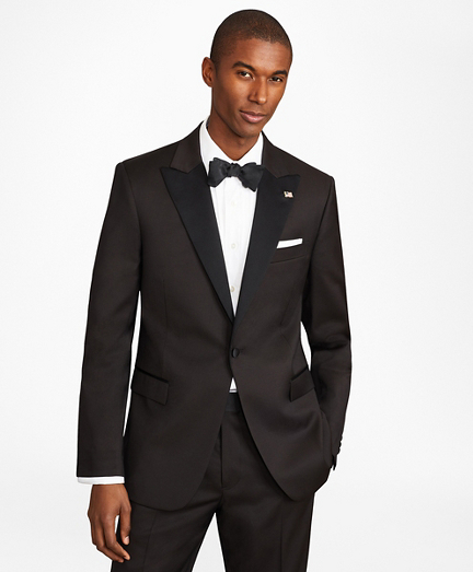 A Black male model wears a black peaked lapel tuxedo in an advertisement from Brooks Brothers 